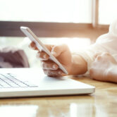Businessman using laptop and mobile phone. Kontakt