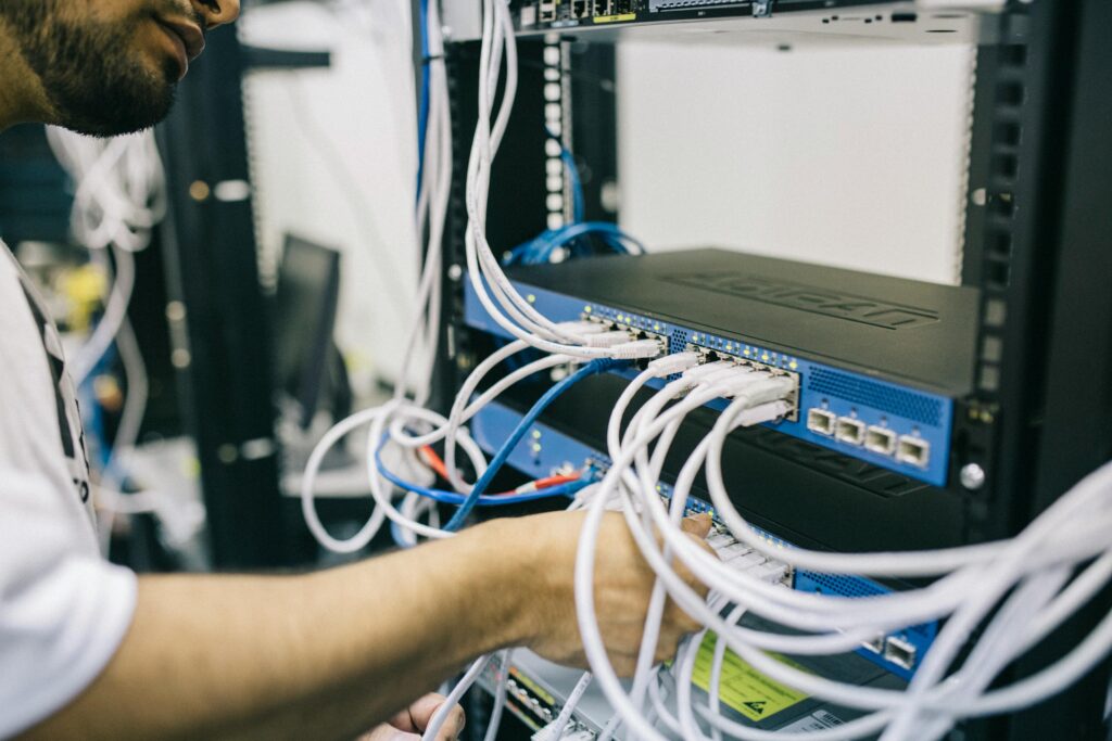 Technik podłącza okablowanie sieciowe serwera NAS