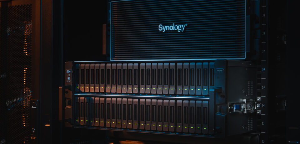 Synology PAS7700 – system storage NVMe all-flash enterprise w szafie rack, widoczne zatoki dysków U.3 NVMe z podświetleniem LED