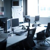 Biuro IT i planowanie projektu Otwarte biuro IT z monitorami i tablicą do planowania projektu