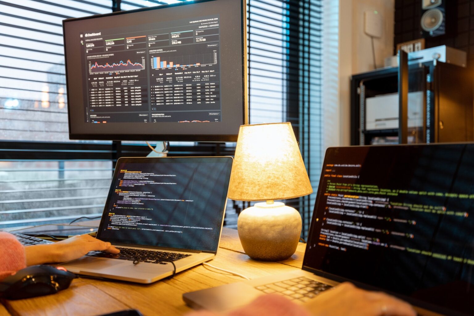 Outsourcing programistów 1 Programistka pracuje nad kodem projektu klienta na kilku monitorach