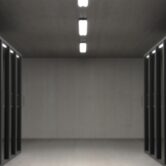 Pusty korytarz serwerowni z szafami rack po obu stronach – serwery z Windows Server 2016 przed końcem wsparcia