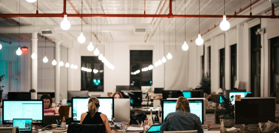 Zespół programistów przy komputerach w biurze software house’u