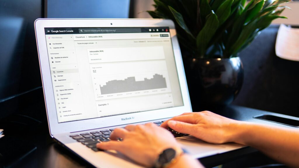 SEO dla software house 6 Osoba pisze tekst ekspercki na laptopie przy drewnianym stole