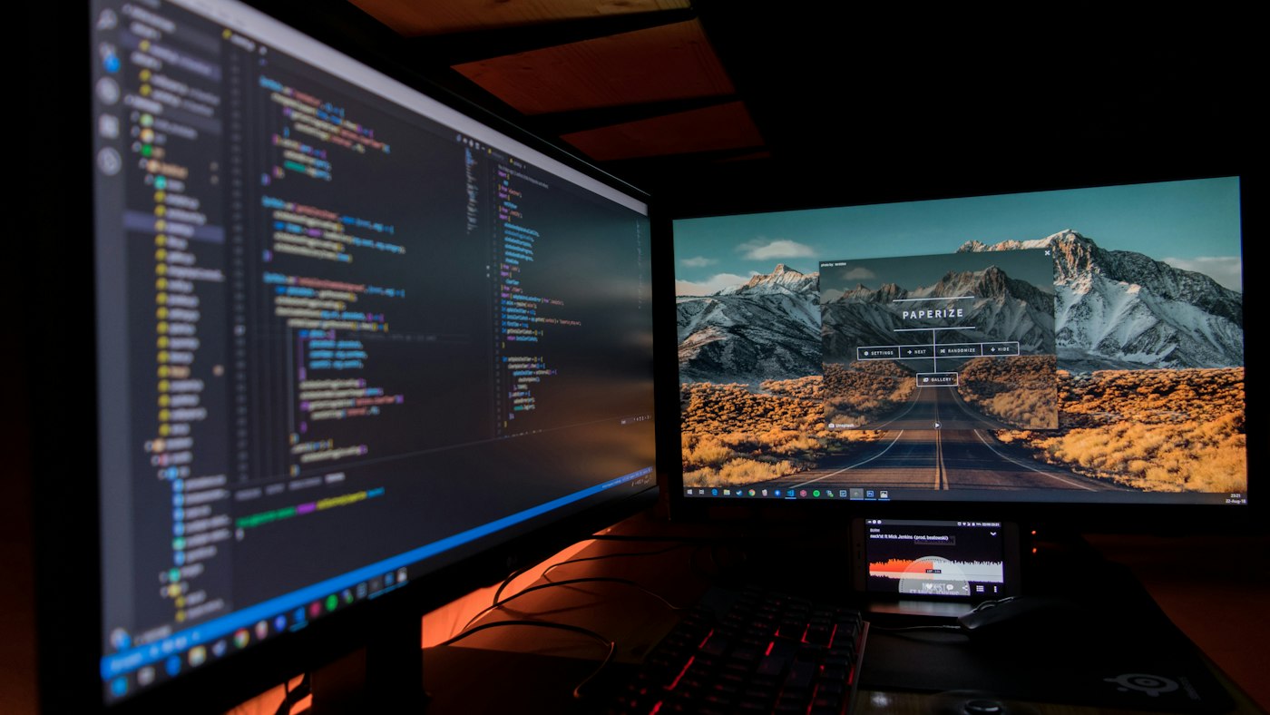 Dwa monitory z otwartym terminalem i pulpitem Linuxa